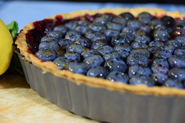 Stardew Valley Blueberry Tart in pan with basil and lemon