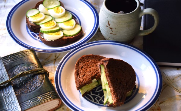 cucumber sandwiches surrounded by a mug and books